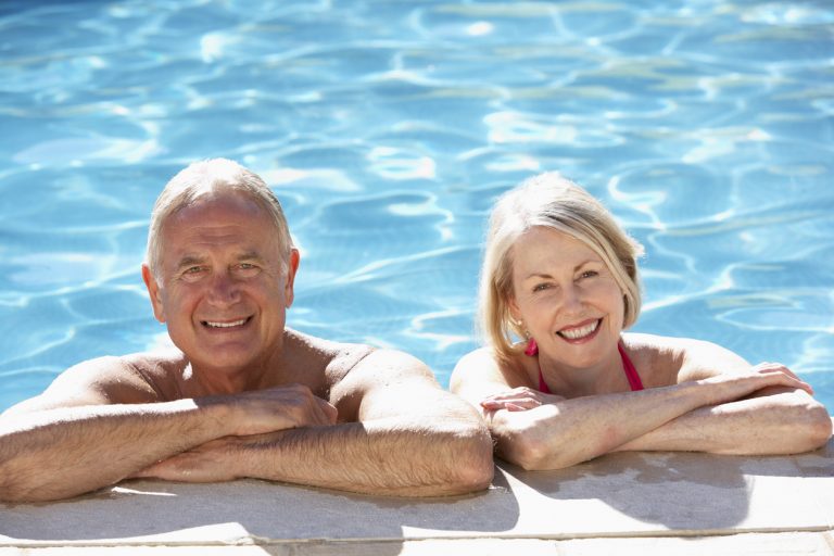 Senior Couple Relaxing In Swimming Pool